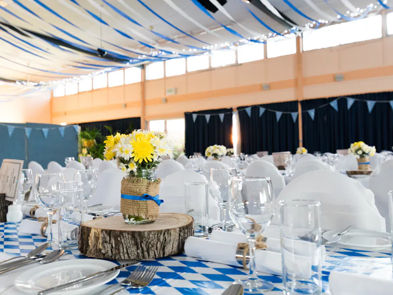 A hall set with long tables and simple centerpieces