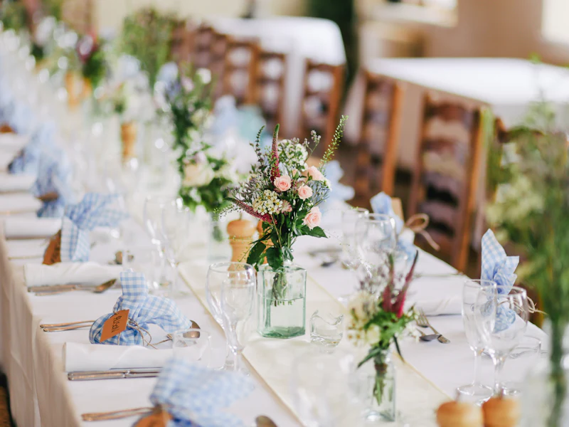 A long table styled with flowers, glassware, and place settings